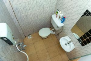 een kleine badkamer met een toilet en een wastafel bij COZY COOL ,WIFI 6 MINS WALK TO ACACIA MALL in Kampala