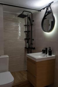 y baño con lavabo, aseo y espejo. en Ophelia - New Modern Apartment with Spectacular Olympus View, en Litóchoron