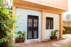 een huis met twee deuren en twee potplanten bij COZY COOL ,WIFI 6 MINS WALK TO ACACIA MALL in Kampala
