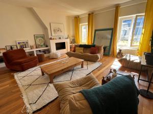 a living room with a couch and a coffee table at Appartement Versailles 5 mn à pied château et gare Versailles Rive Gauche Château in Versailles +3 photos