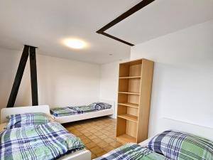 1 dormitorio con 2 camas y estante para libros en Work & Stay Apartments in Leverkusen en Leverkusen