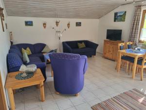 ein Wohnzimmer mit einem blauen Sofa und einem Tisch in der Unterkunft Bei Schneider's in Ruhpolding