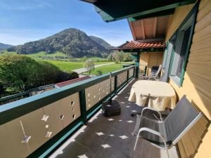 een balkon met een tafel en stoelen en bergen bij Bei Schneider's in Ruhpolding