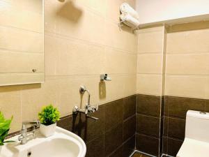 y baño con lavabo y ducha. en Hotel MN Grand Shamshabad Airport Zone Hyderabad, en Shamshabad