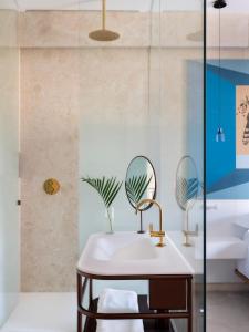 uma casa de banho com um lavatório e 2 espelhos em Kimpton Las Mercedes, an IHG Hotel em Santo Domingo