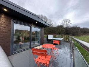 a deck with a table and chairs and a grill at Laigh Letterpin Lodge in Girvan