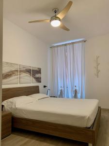 a bedroom with a bed with a ceiling fan at San Rocco Apartments in Riva del Garda