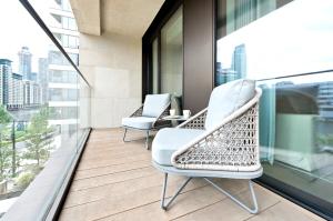 two chairs on a balcony with a view of the city at Elegant and Modern Apartments in Canary Wharf right next to Thames in London