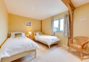 a bedroom with two beds and a window at Pheasant Lodge in Reepham