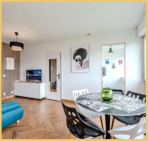 uma sala de jantar e sala de estar com mesa e cadeiras em Chez Fan & Alex St Julien em Saint-Julien-en-Genevois