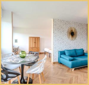 uma sala de estar com um sofá azul e uma mesa em Chez Fan & Alex St Julien em Saint-Julien-en-Genevois