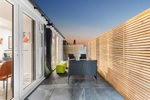 沃辛的住宿－Lovely Penthouse in Worthing - Sleeps 6，阳台配有木制百叶窗和桌椅。