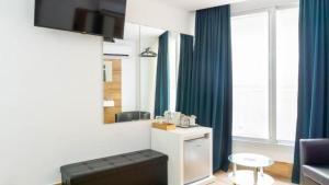 a bathroom with blue curtains and a vanity with a mirror at Ilustre Rooms by Beehive Vacances in Málaga