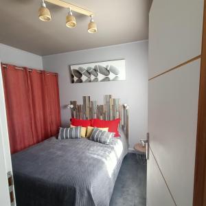 een slaapkamer met een groot bed met rode gordijnen bij Studio les pieds dans l'eau App n°7 in Le Barcarès