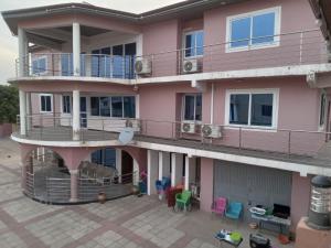 een appartementencomplex met een balkon en kleurrijke stoelen bij Captivating 1-Bed Lodge in Accra in Accra