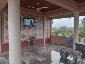a room with a balcony with a tv on the wall at Captivating 1-Bed Lodge in Accra in Accra