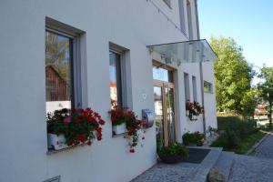um edifício branco com flores em caixas de janela em Wein + Bett Wiedeck em Stetten