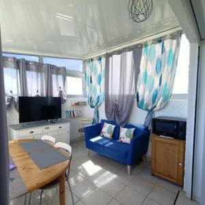 een woonkamer met een blauwe bank en een tafel bij Studio les pieds dans l'eau App n°7 in Le Barcarès