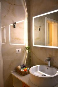 a bathroom with a sink and a mirror at Central Comfy Apartment in Tirana