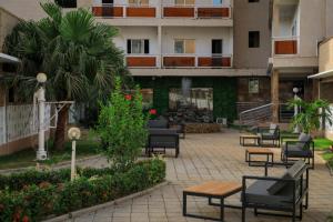 a courtyard with chairs and tables in a building at HÔTEL MARIADOR PARK in Conakry