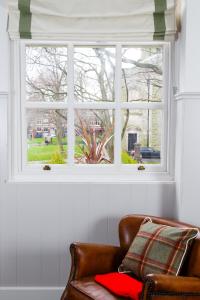 a couch sitting under a window with a red blanket at Saint Pauls House in Birmingham