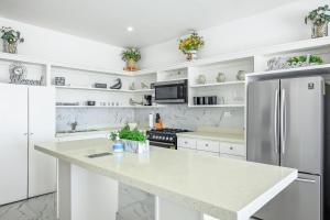 a kitchen with white cabinets and a refrigerator at Casa Platino 22 - Playa Arcangel in Rosarito