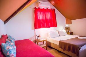 a bedroom with two beds and a red window at Mambembe Hostel in Rio de Janeiro
