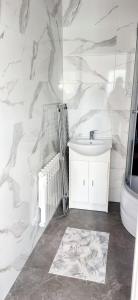 a white bathroom with a sink and a toilet at Noclegi u Ewusi in Januszowice