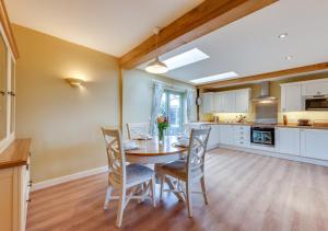 a kitchen and dining room with a table and chairs at Partridge Lodge in Reepham