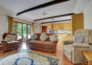 a living room with a couch and two chairs at The Orchard in Lyng