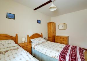 1 dormitorio con 2 camas y muebles de madera en The Orchard, en Lyng