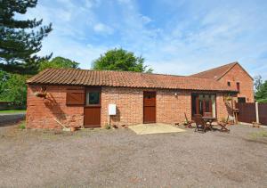 a small brick house with a patio in front of it at The Orchard in Lyng