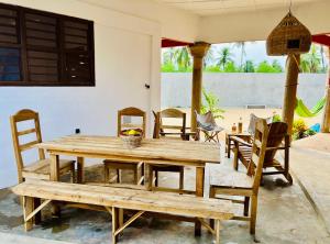 a wooden table and chairs in a room at Amistad in Ouidah