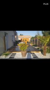 a patio with two potted plants and a house at maison de vacances Lège-cap-ferret in Lège-Cap-Ferret