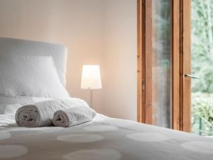 [10 min. da Courmayeur] Elegante Appartamento في حمامات بري ساينت ديدييار: غرفة نوم بسرير ابيض عليها مناشف