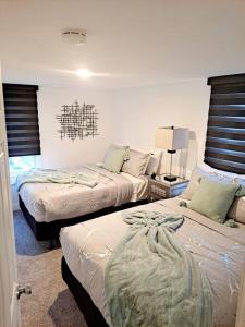 a bedroom with two beds and a table with a lamp at Luxe On Walnut/King Bed/Off St.Parkin/30 days stay in Lancaster