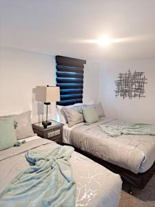 um quarto com 2 camas e uma mesa com um candeeiro em Luxe On Walnut/King Bed/Off St.Parkin/30 days stay em Lancaster