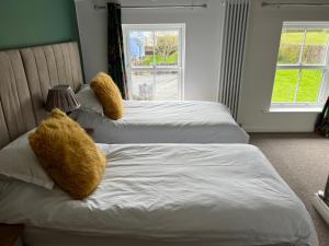 two beds with teddy bears on them in a bedroom at Willow Mews in Swansea