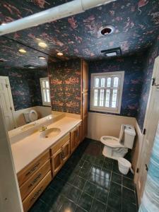 y baño con lavabo y aseo. en Grand Tudor Mansion with Pool near Germantown, en Memphis