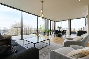 een woonkamer met banken en een tafel bij 12B, Luxe Designer Oase ~ Historisch Centrum ~ Uitzicht in Oisterwijk