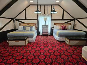 Habitación con 2 camas y alfombra roja. en Grand Tudor Mansion with Pool near Germantown, en Memphis