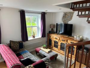 a living room with a couch and a flat screen tv at Willow Mews in Swansea