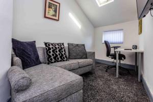 a living room with a couch and a desk at Guest Homes - Bambro Apartment in Sunderland