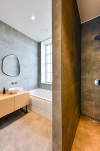奧斯特韋克的住宿－12, Luxe Designer Oase - Historisch Centrum - Uitzicht，一间带水槽、浴缸和镜子的浴室