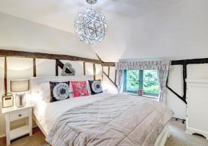 um quarto com uma cama grande e um lustre em The Cottage em Scole