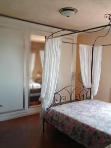 1 dormitorio con cama con dosel y cortinas blancas en "Le Chat Libre" Alloggio Turistico, en Monte San Biagio