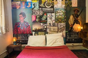 a room with a bed with posters on the wall at Mambembe Hostel in Rio de Janeiro