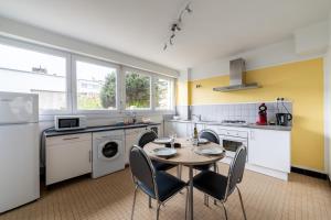 a kitchen with a table and chairs in a room at RDC FACE A LA MER in Dunkerque