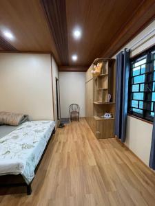 um quarto com uma cama e piso em madeira em Mộc Homestay em Mộc Châu