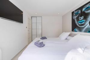 Un dormitorio con una cama blanca con toallas. en Beautiful 2P apartment with sunny terrace, en Cannes